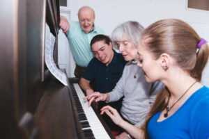 Young couple visiting grandparents and playing piano in the living room